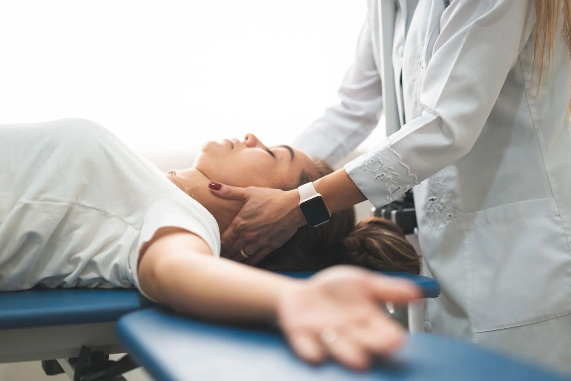 Person receiving neck massage in a medical setting.