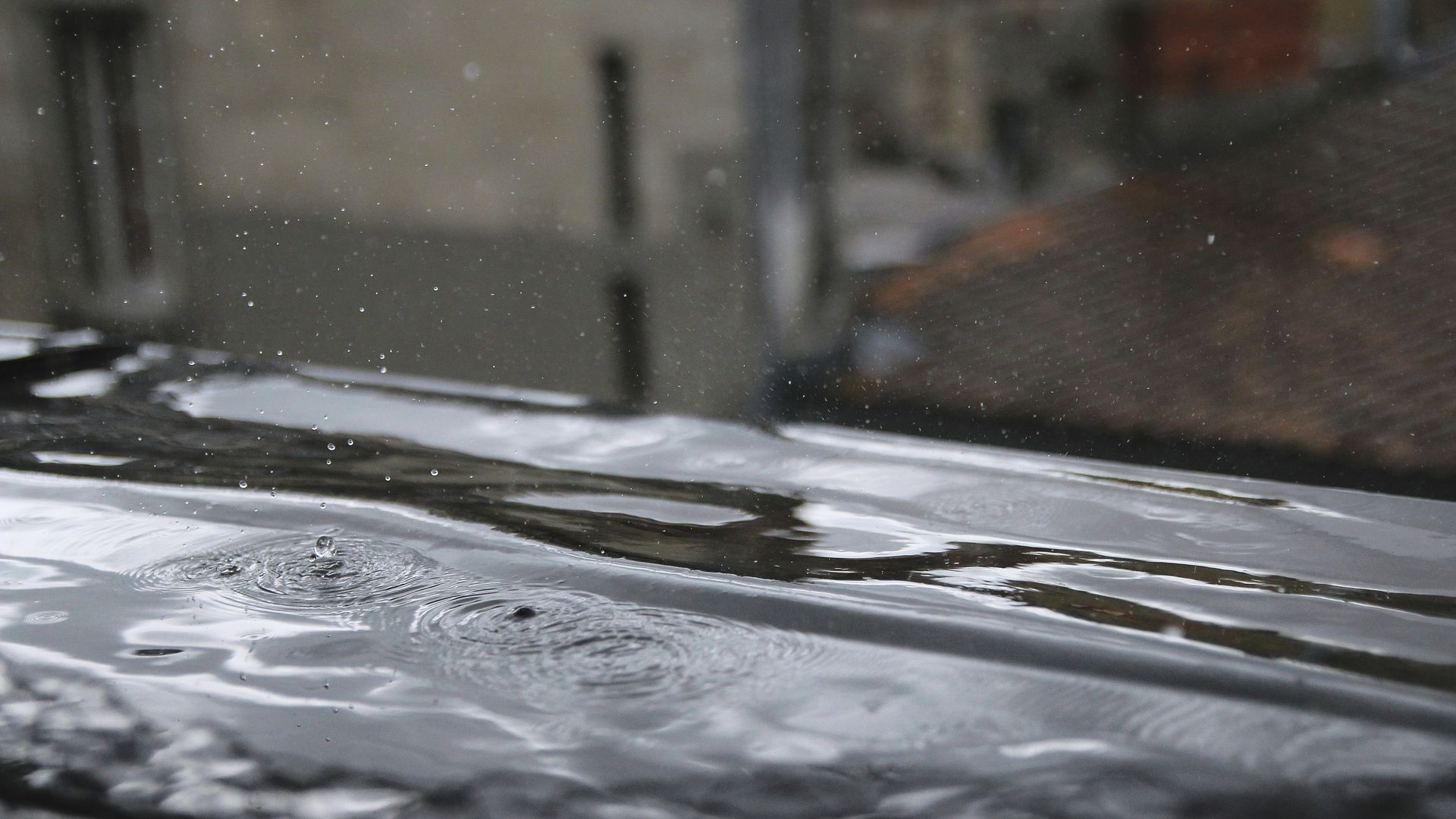 The underside of a mobile home structure featuring a metal frame, concrete piers, and ground covered by a vapor barrier.