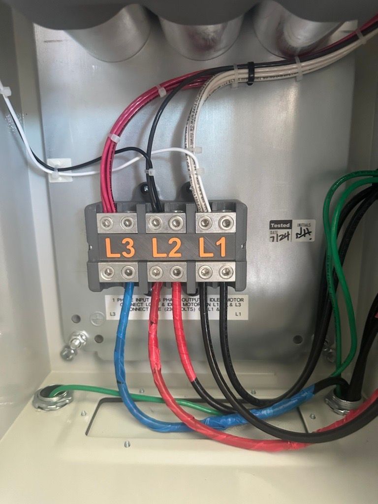 A close up of a electrical box with wires coming out of it.