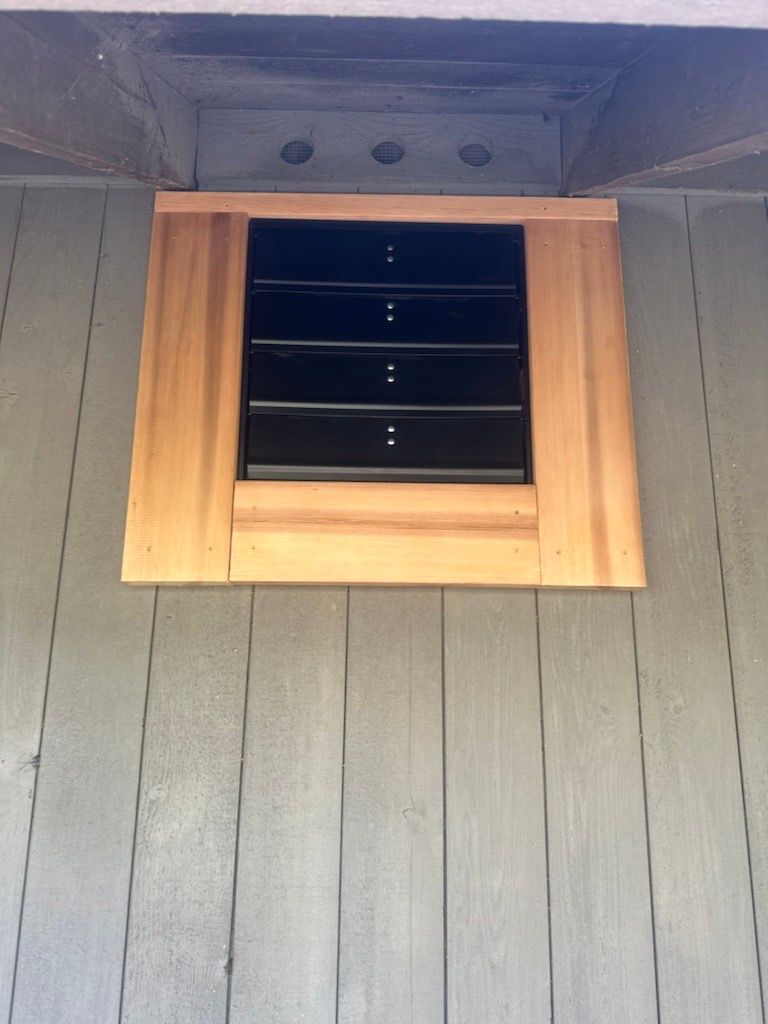 A wooden window with a black shutter on it