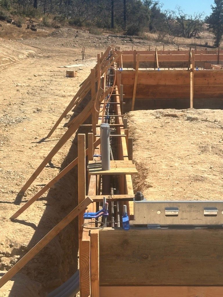 A wooden fence is being built in a dirt field