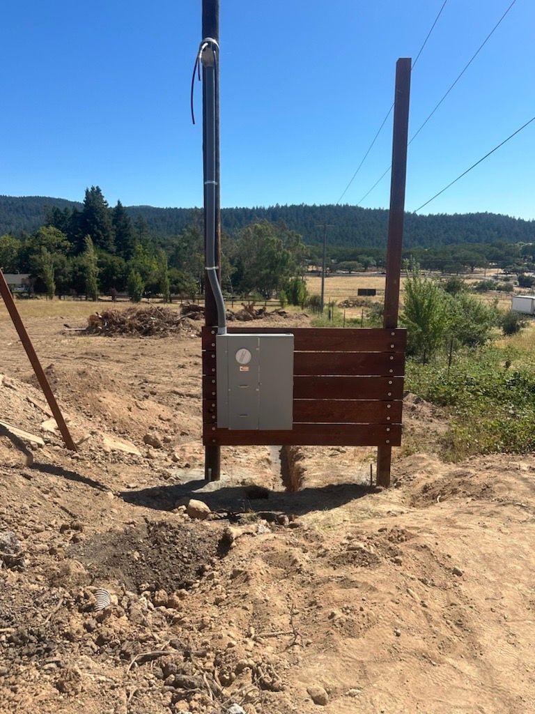 A wooden sign is sitting in the middle of a dirt field.
