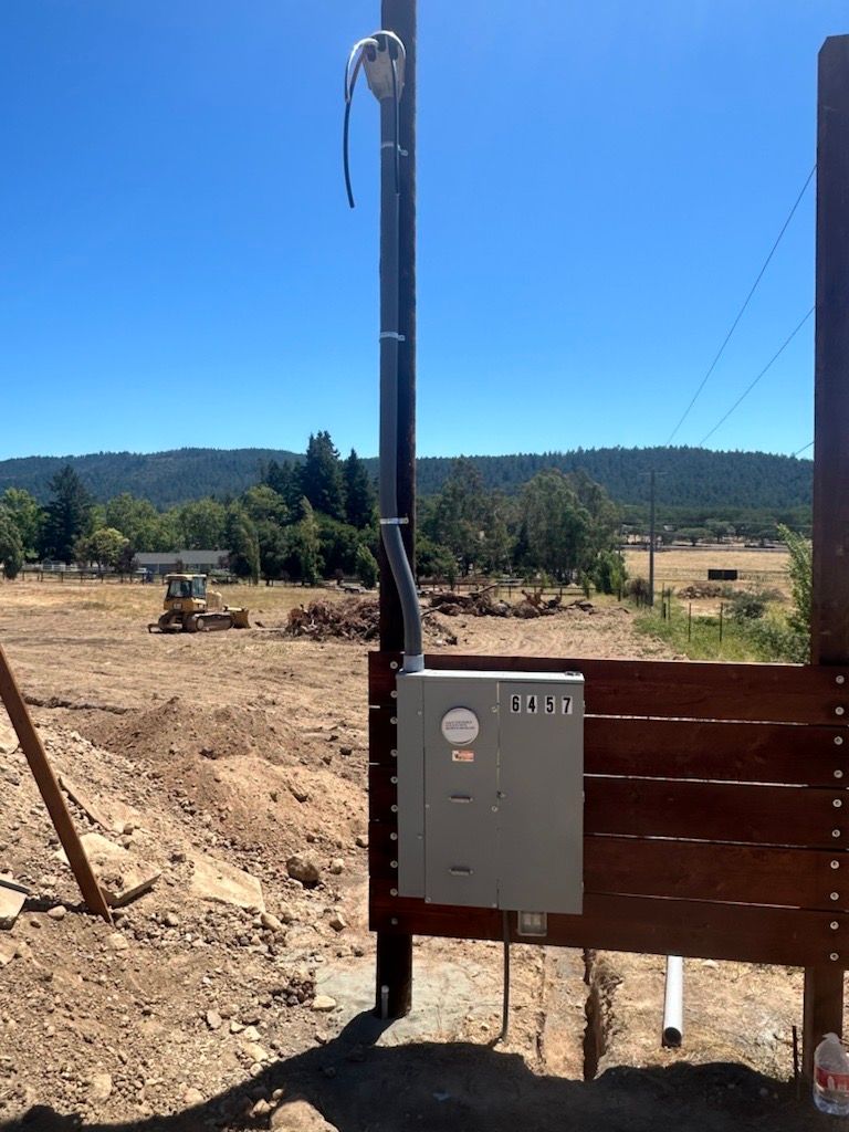 A wooden fence with a box on it that says ' electrical ' on it