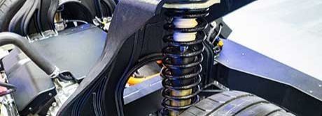 Close-up of a car's suspension system with a shock absorber and coil spring.