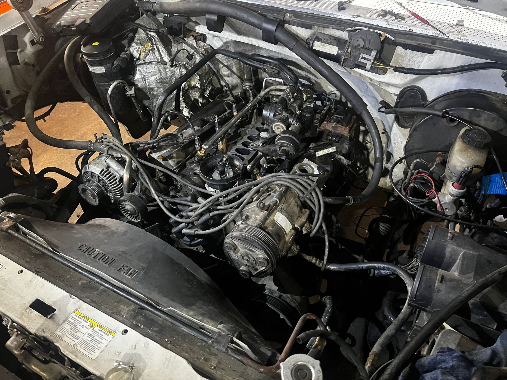Engine of a white truck, showing wiring and components under the hood.
