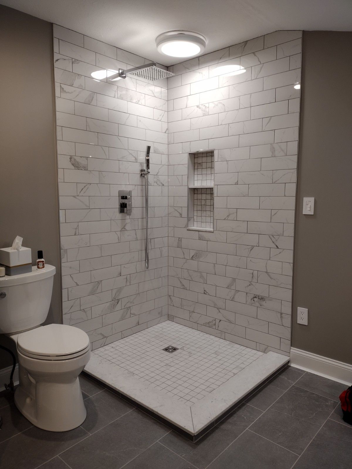 A bathroom with a toilet and a walk in shower.