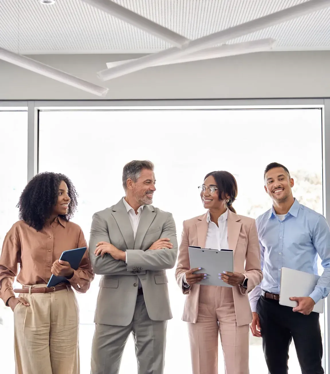 A group of business people are standing next to each other in an office.