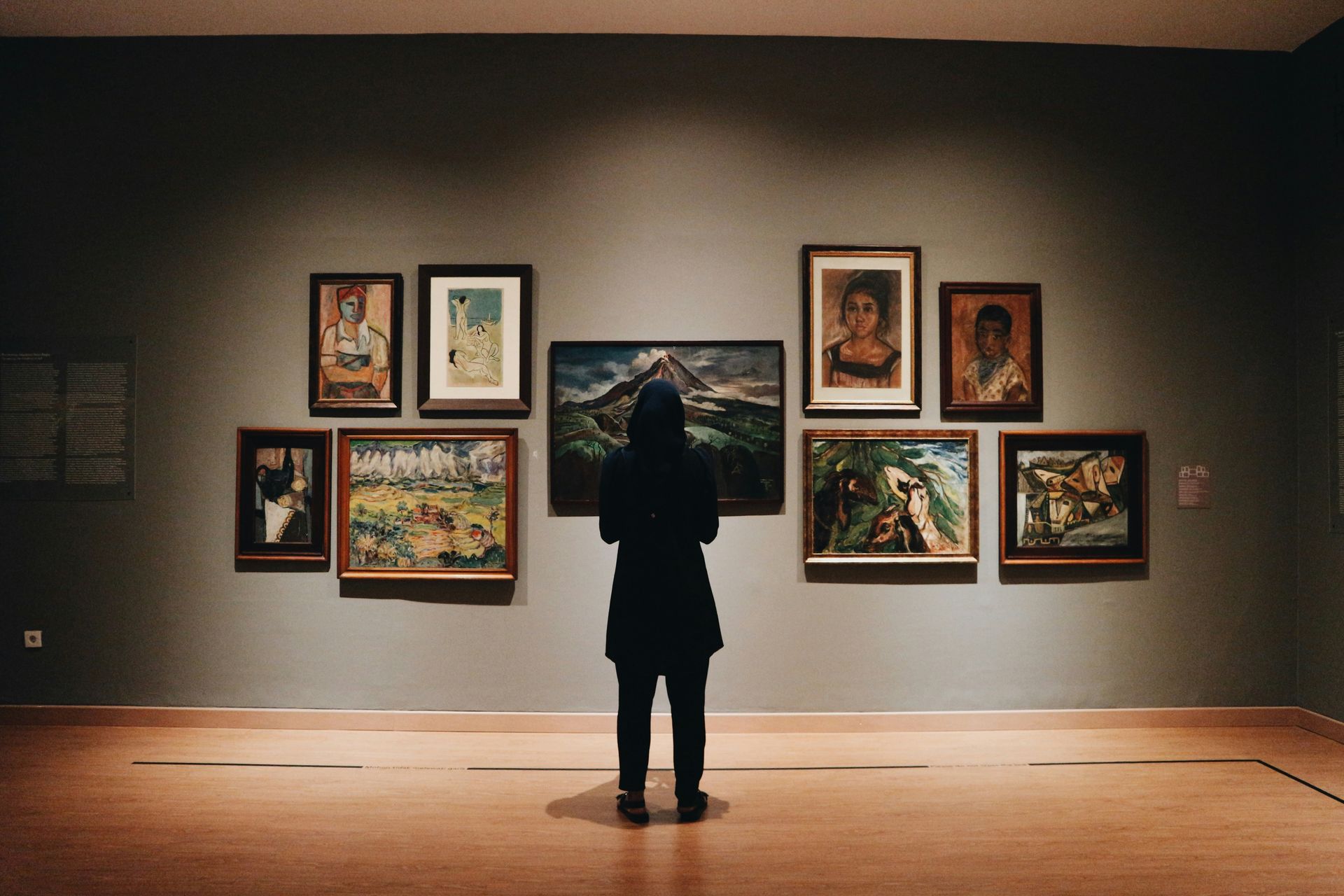 A woman looking at the paintings on the wall