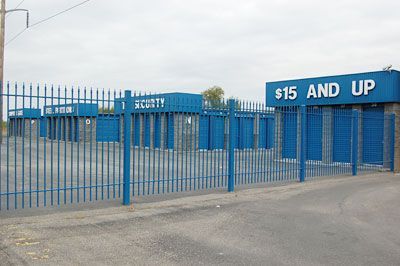 A blue fence surrounds a building that says $ 15 and up