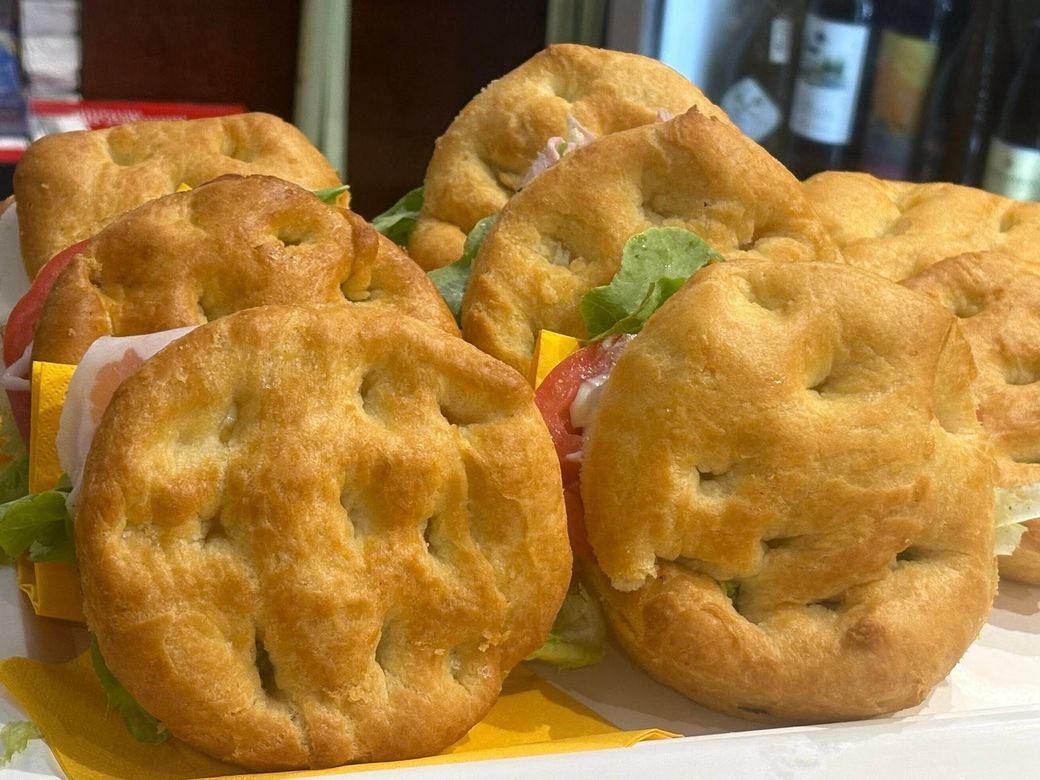 Panini con pane focaccia, farciti con lattuga, formaggio e pomodori.