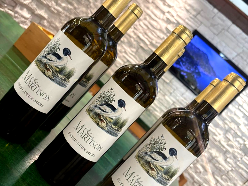 Quattro bottiglie di vino bianco, etichettate 
