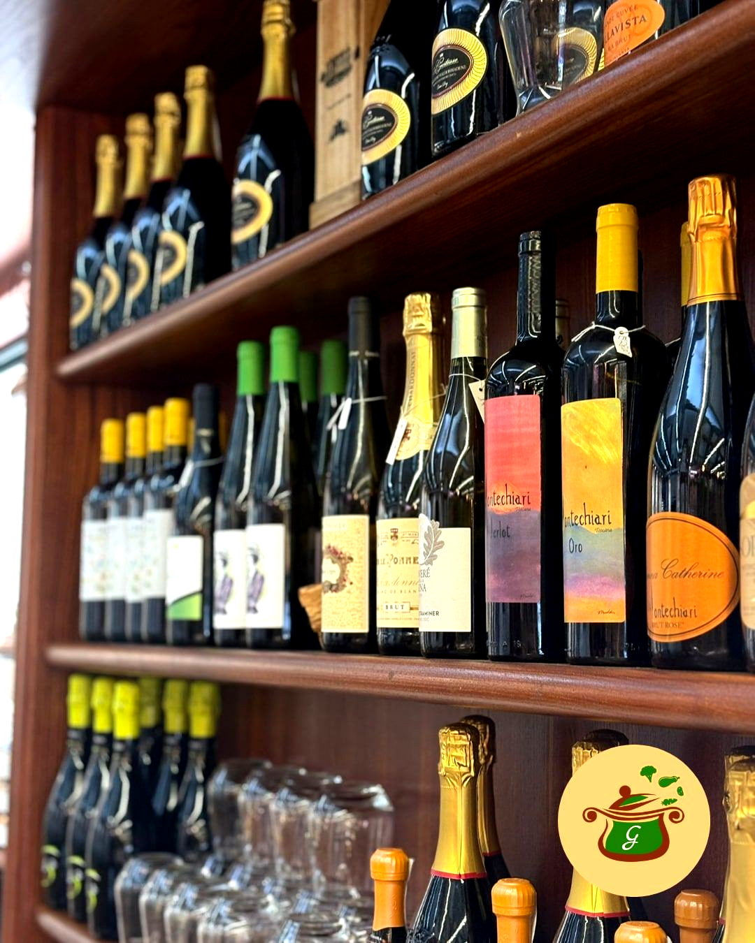 Scaffali pieni di varie bottiglie di vino, cornice in legno.