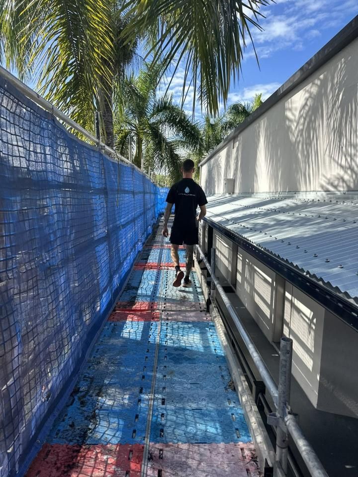 Person Walking in Scaffolding Beside a Roof — HFB Plumbing & Gas in Edmonton, QLD