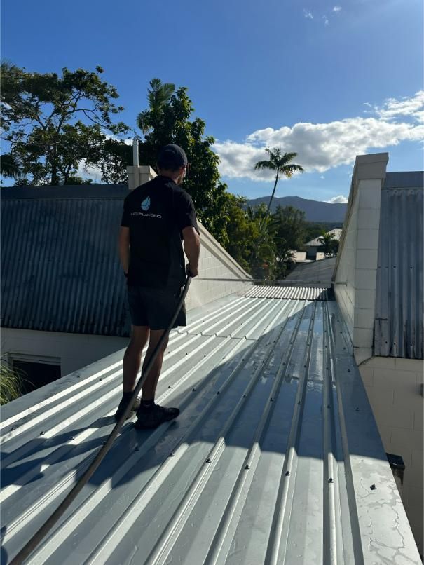 Person Pressure Washing a Corrugated Metal Roof on a Sunny Day — HFB Plumbing & Gas in Edmonton, QLD