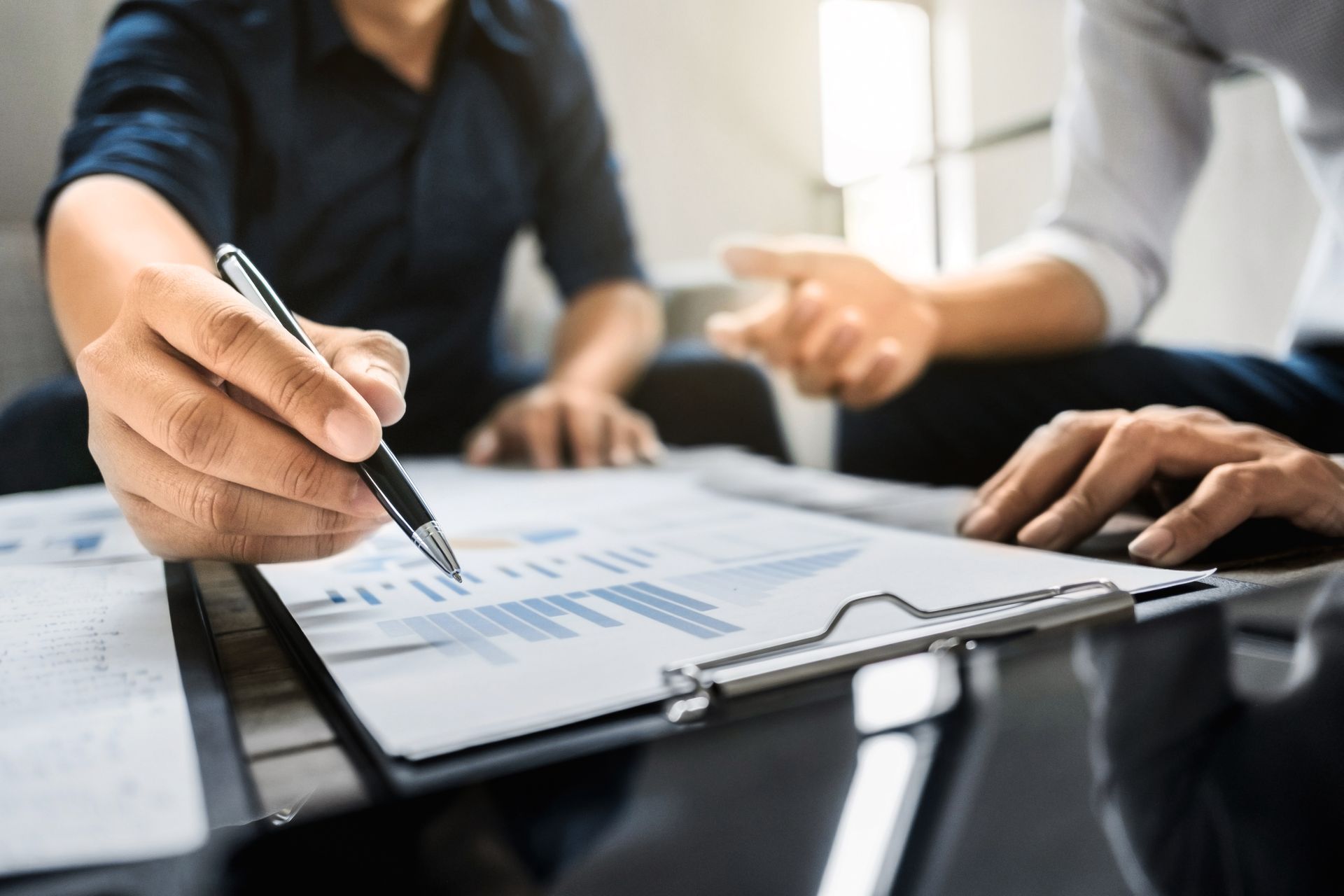 Business handshake overlaid on a city skyline, with blurred silhouettes of people.