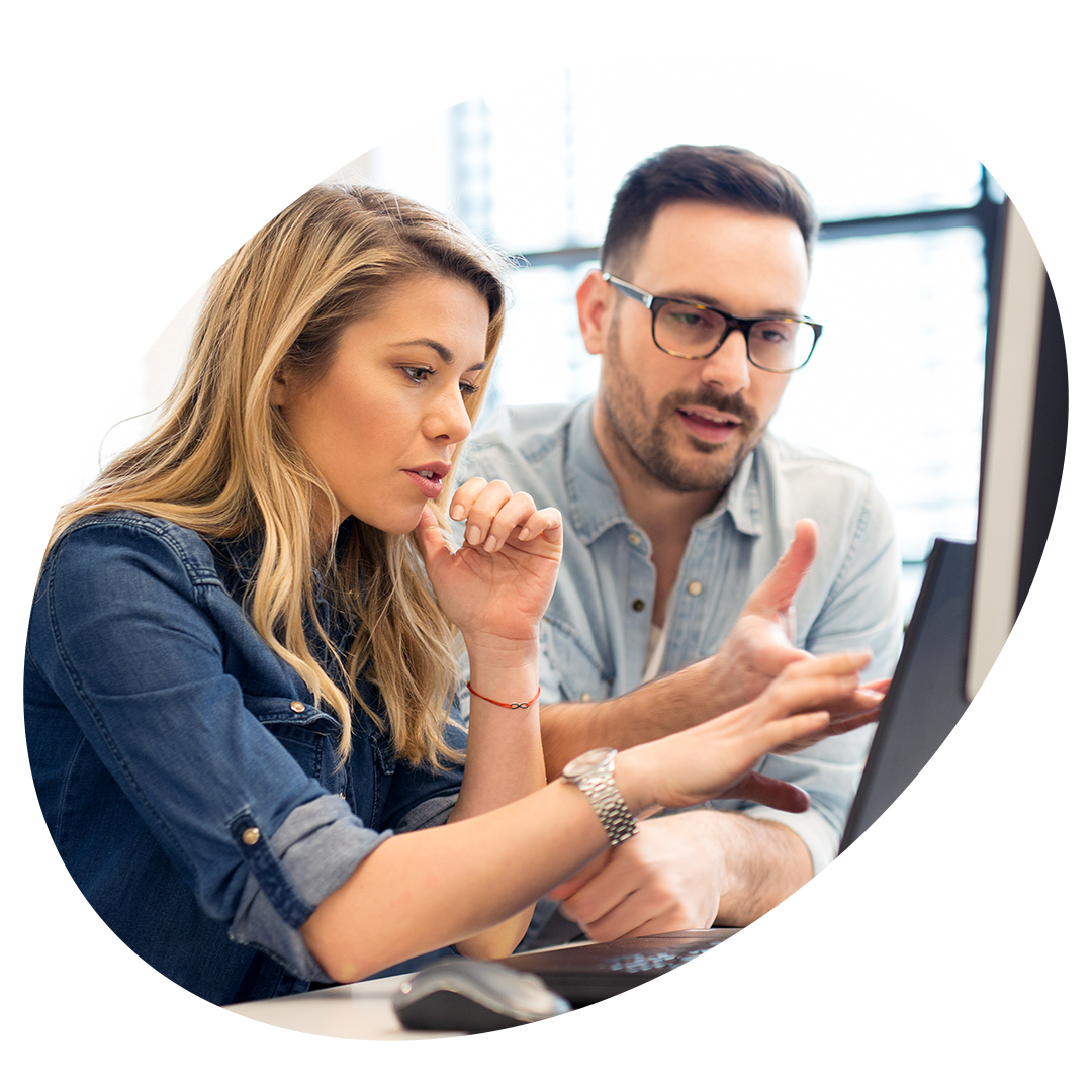 A man and a woman are looking at a computer screen.