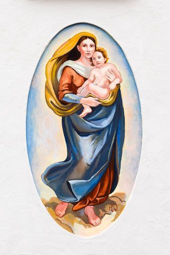 Ein ovales Gemälde, das eine Frau in gelbem Schleier und blauen Gewändern zeigt, die ein kleines Kind im Arm hält.