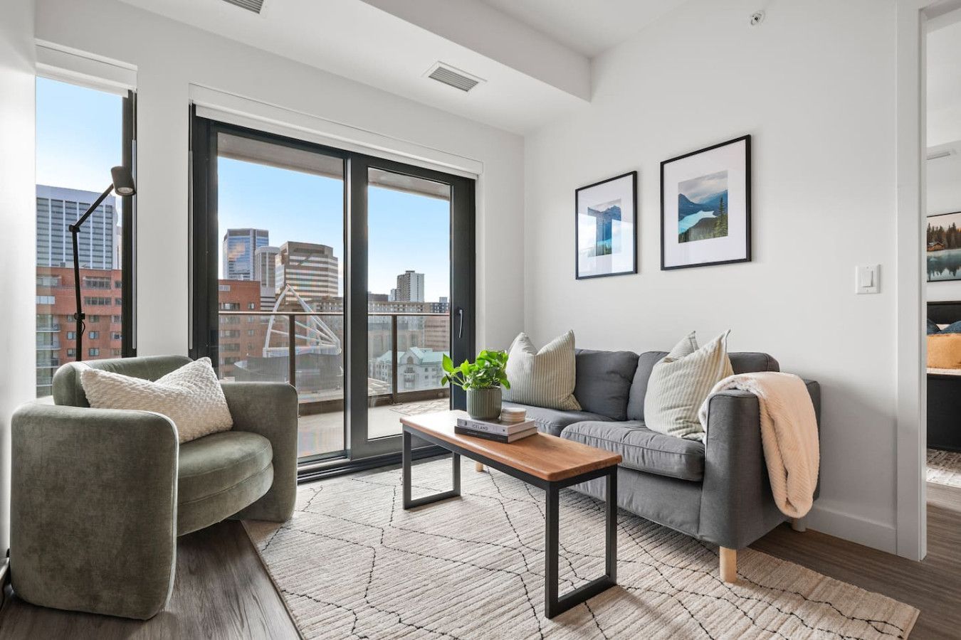 A living room with a couch , chair , coffee table and sliding glass doors.
