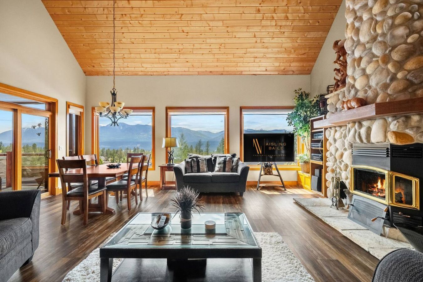 A living room with two couches , a fireplace and a flat screen tv.