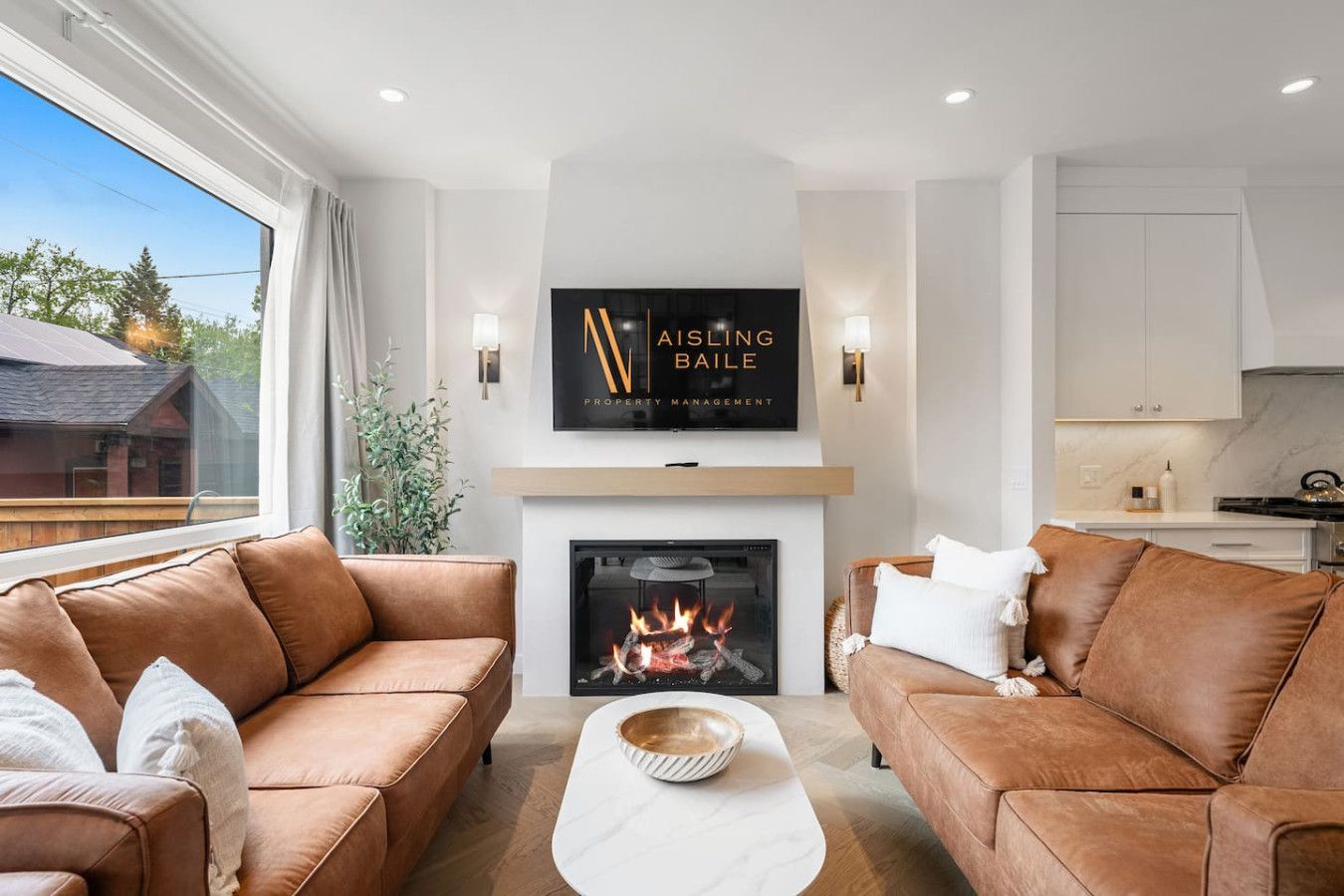 A living room with two couches , a fireplace and a flat screen tv.