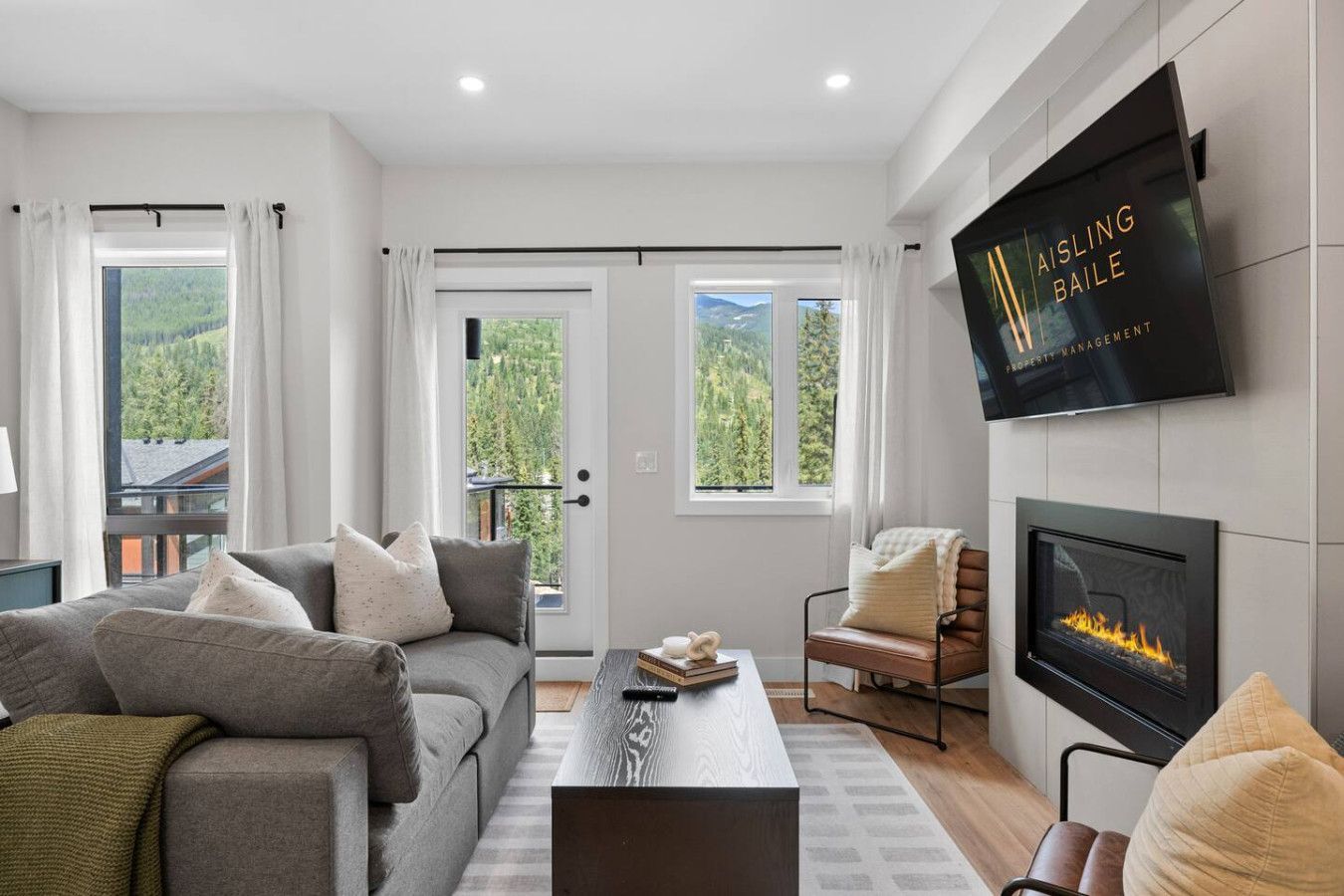 A living room with a couch and chairs and a view of the city