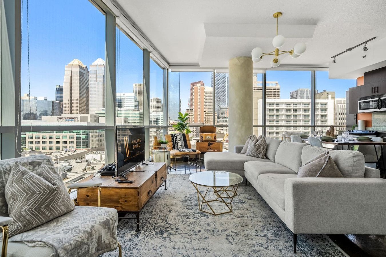 A living room with a couch and chairs and a view of the city