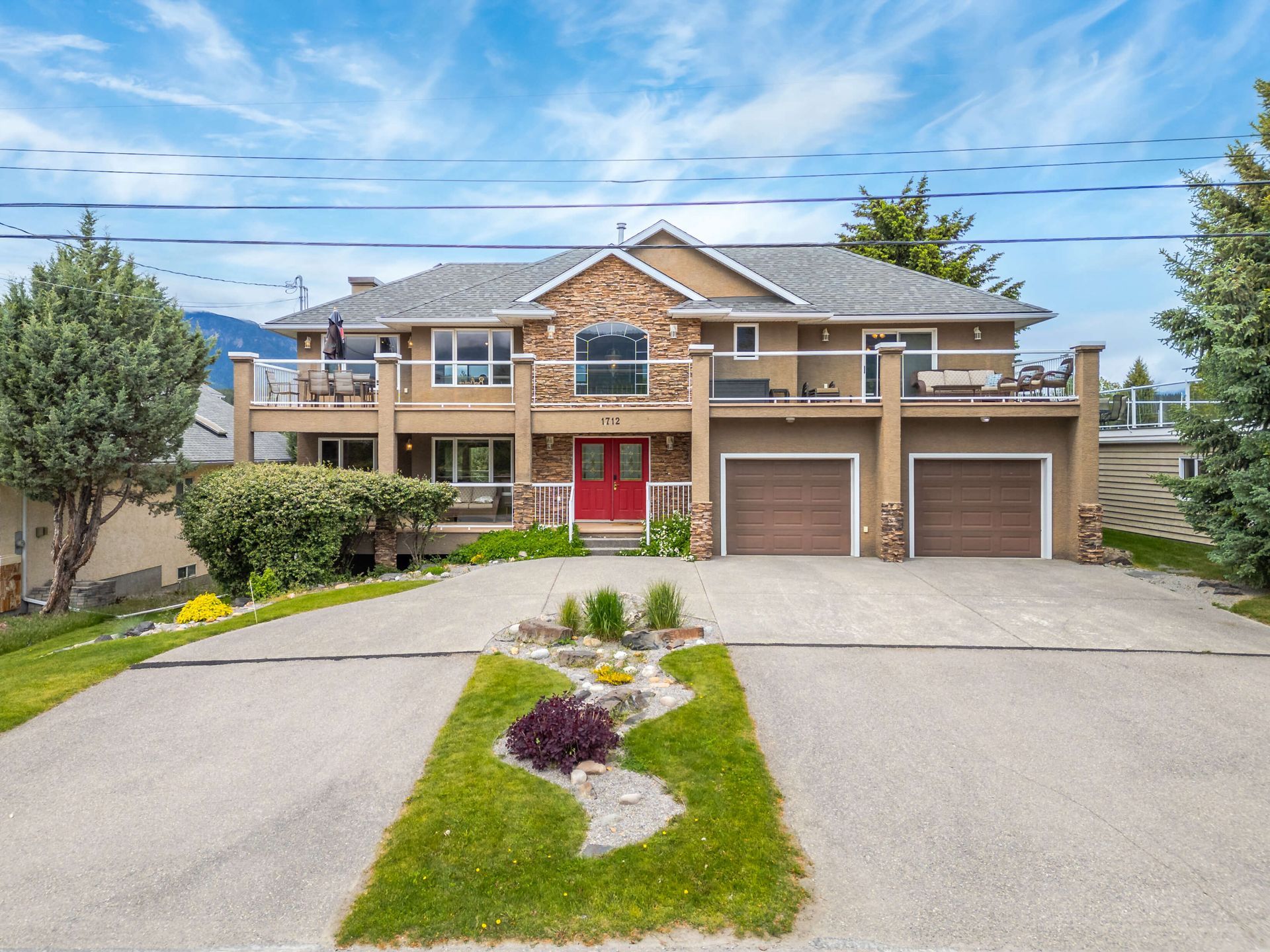A large house with two garages and a red door