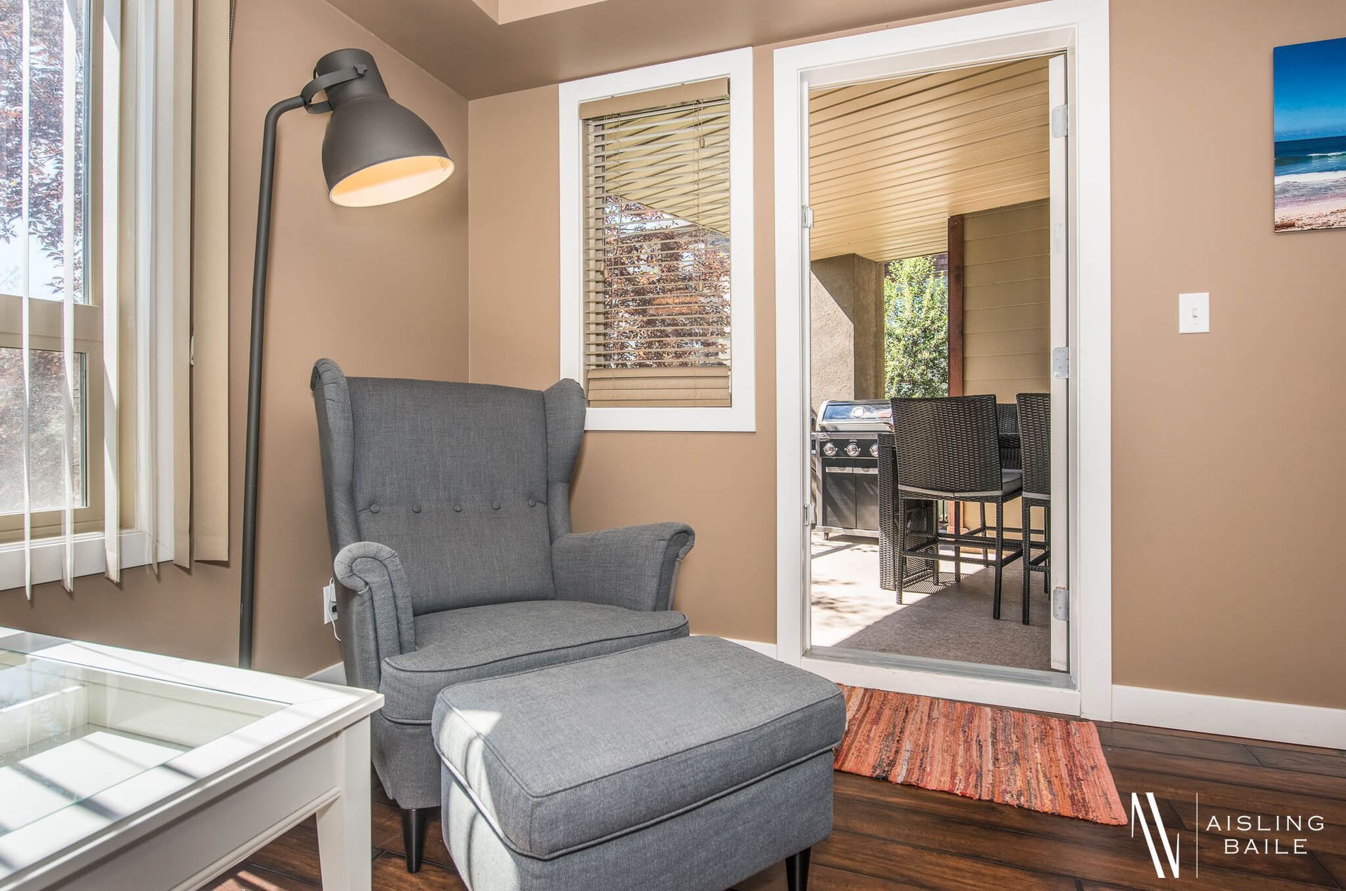 Living room chair and patio entrance of the Stylish condo of Lake Windermere Pointe in Invermere, a BC Vacation Rental hosted by Aisling Baile Property Management.