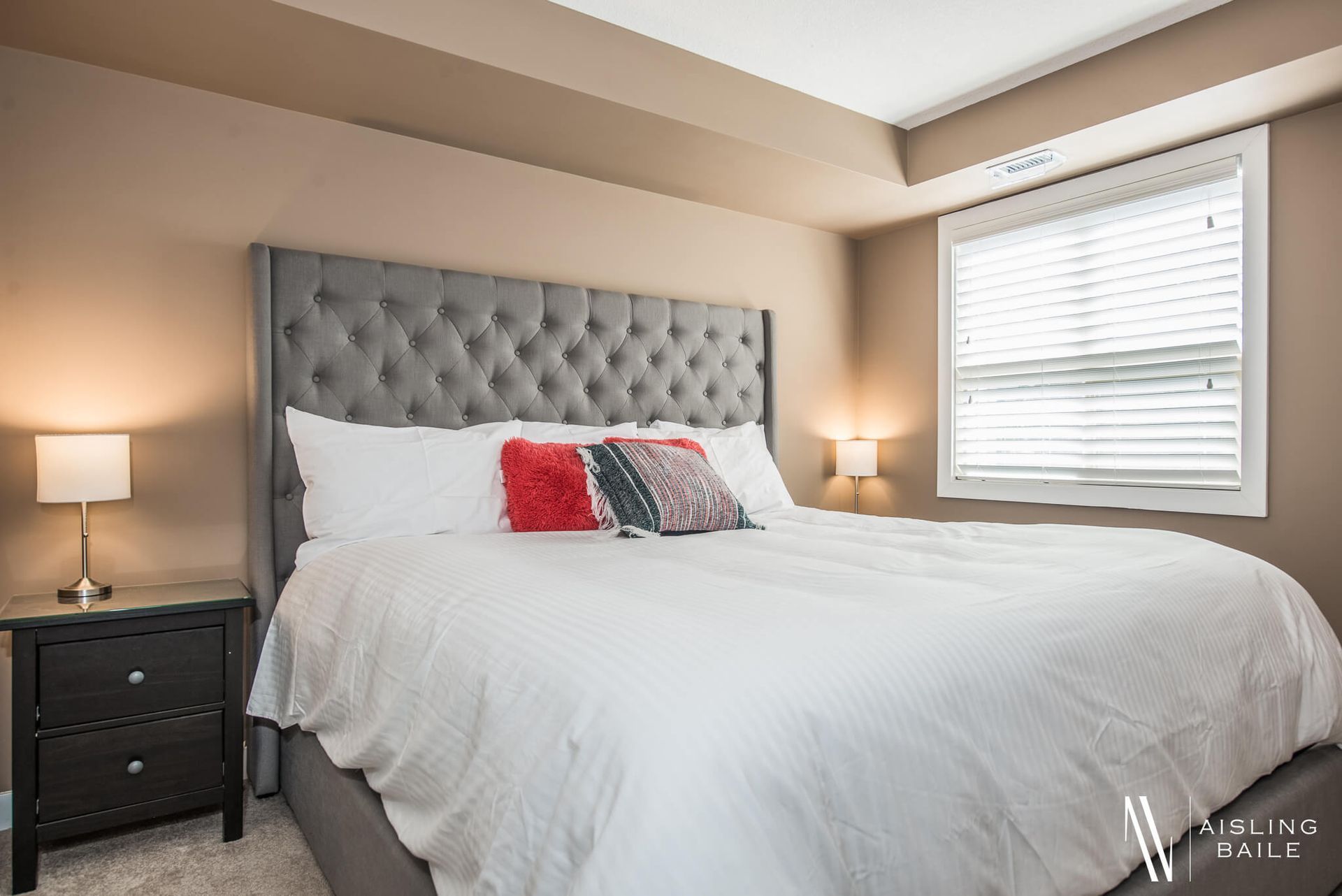 Primary bedroom with a king bed in the Stylish condo of Lake Windermere Pointe in Invermere, a BC Vacation Rental hosted by Aisling Baile Property Management.