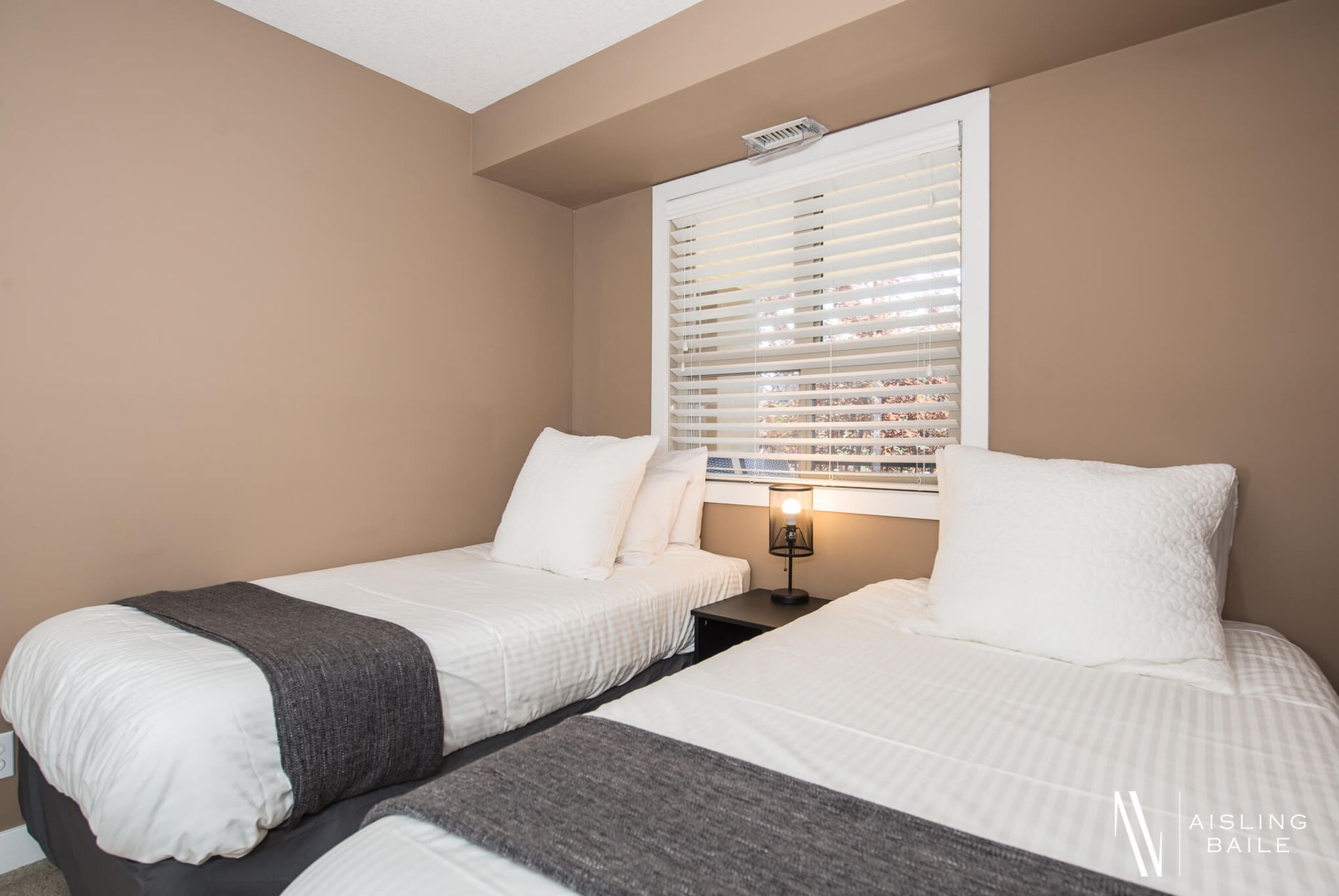 Second bedroom with two single beds at the Stylish condo of Lake Windermere Pointe in Invermere, a BC Vacation Rental hosted by Aisling Baile Property Management.
