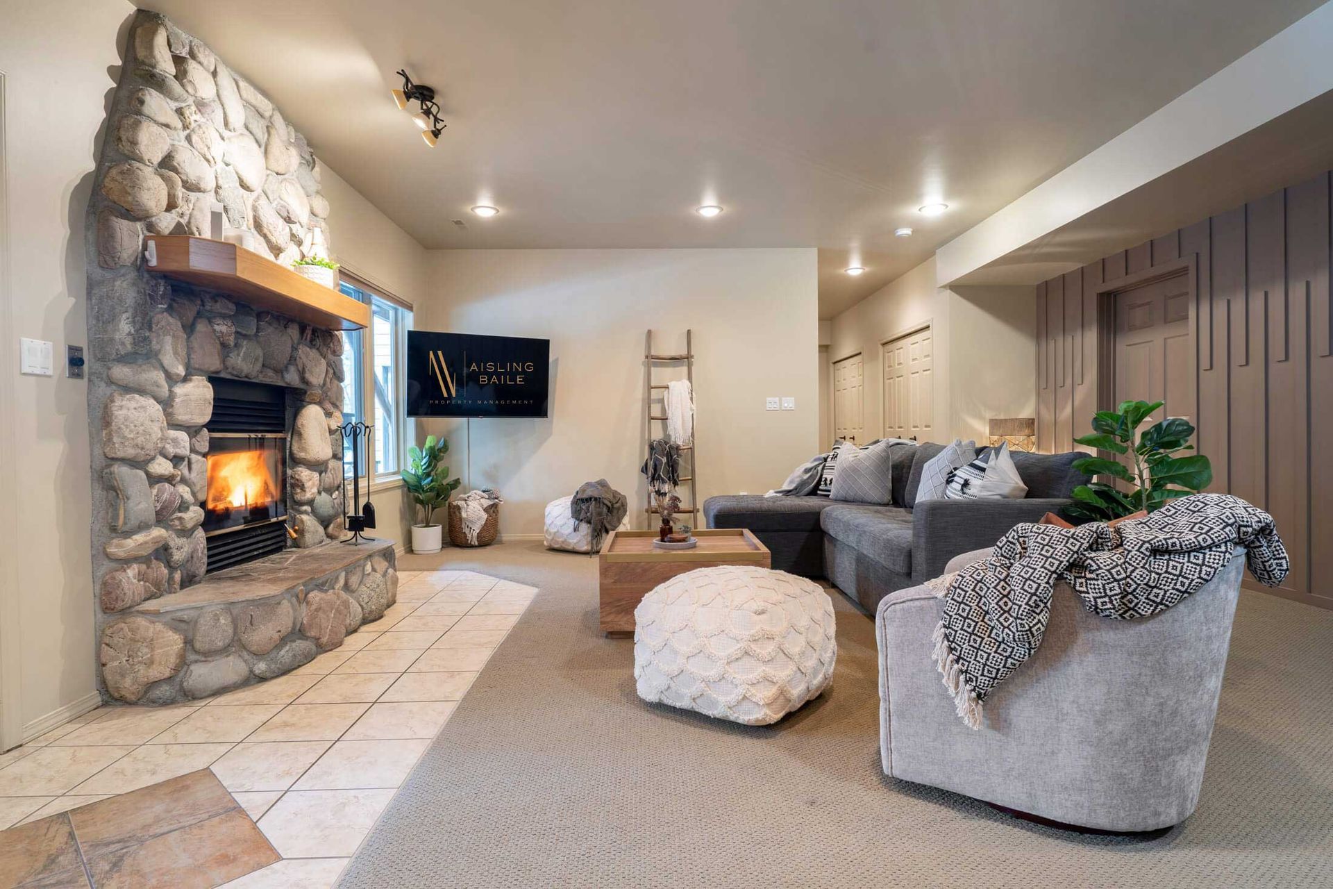 Downstairs living room with wood-burning fireplace of Tranquil Pines, a Fairmont Hot Springs BC Vacation Rental hosted by Aisling Baile Property Management.