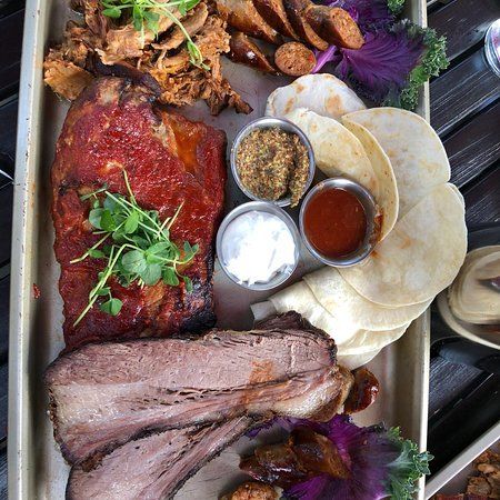 A tray of meat and vegetables on a wooden table.