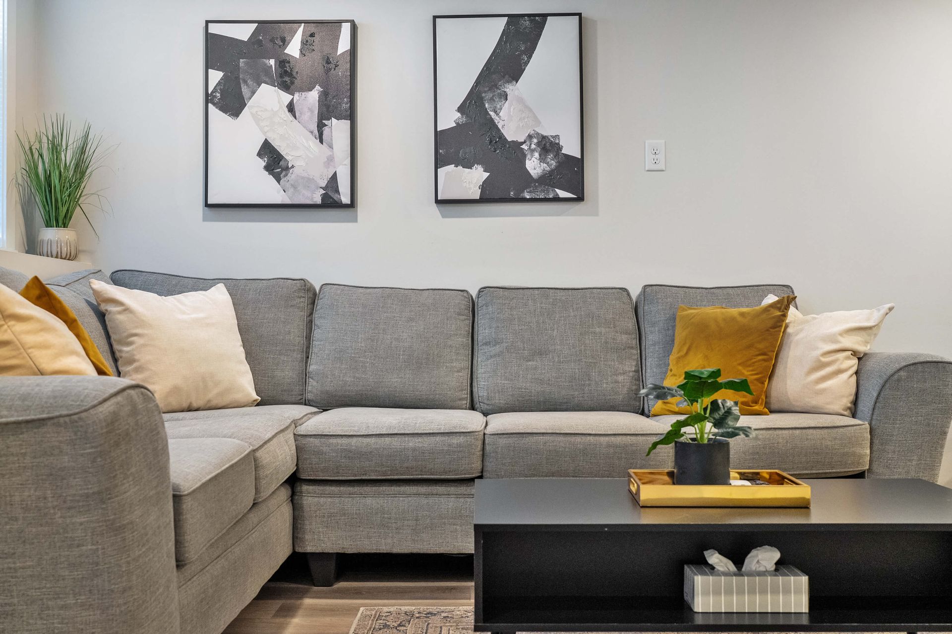 A living room with a large sectional couch and a coffee table.