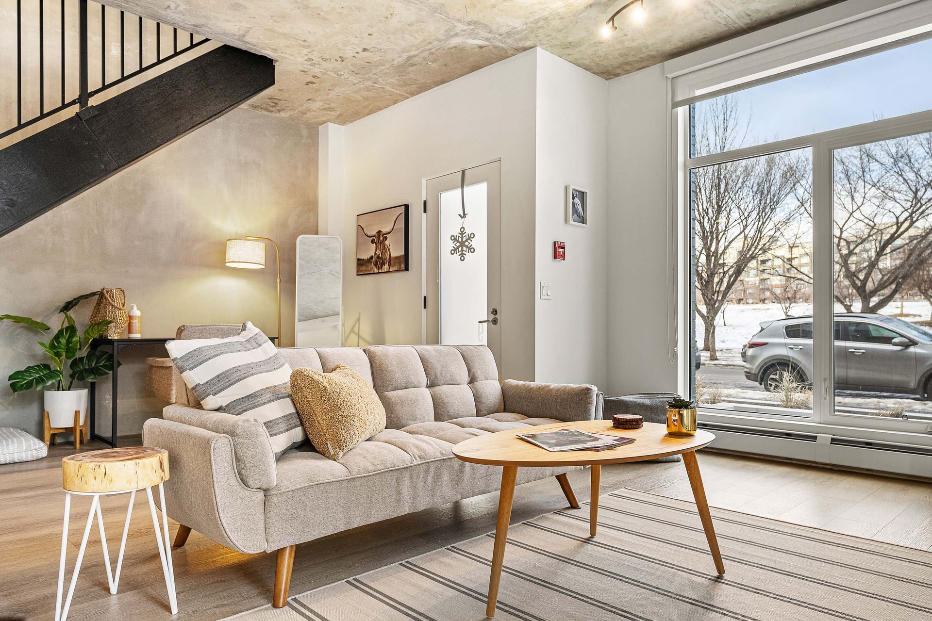 A living room with a couch , chair , coffee table and rug.