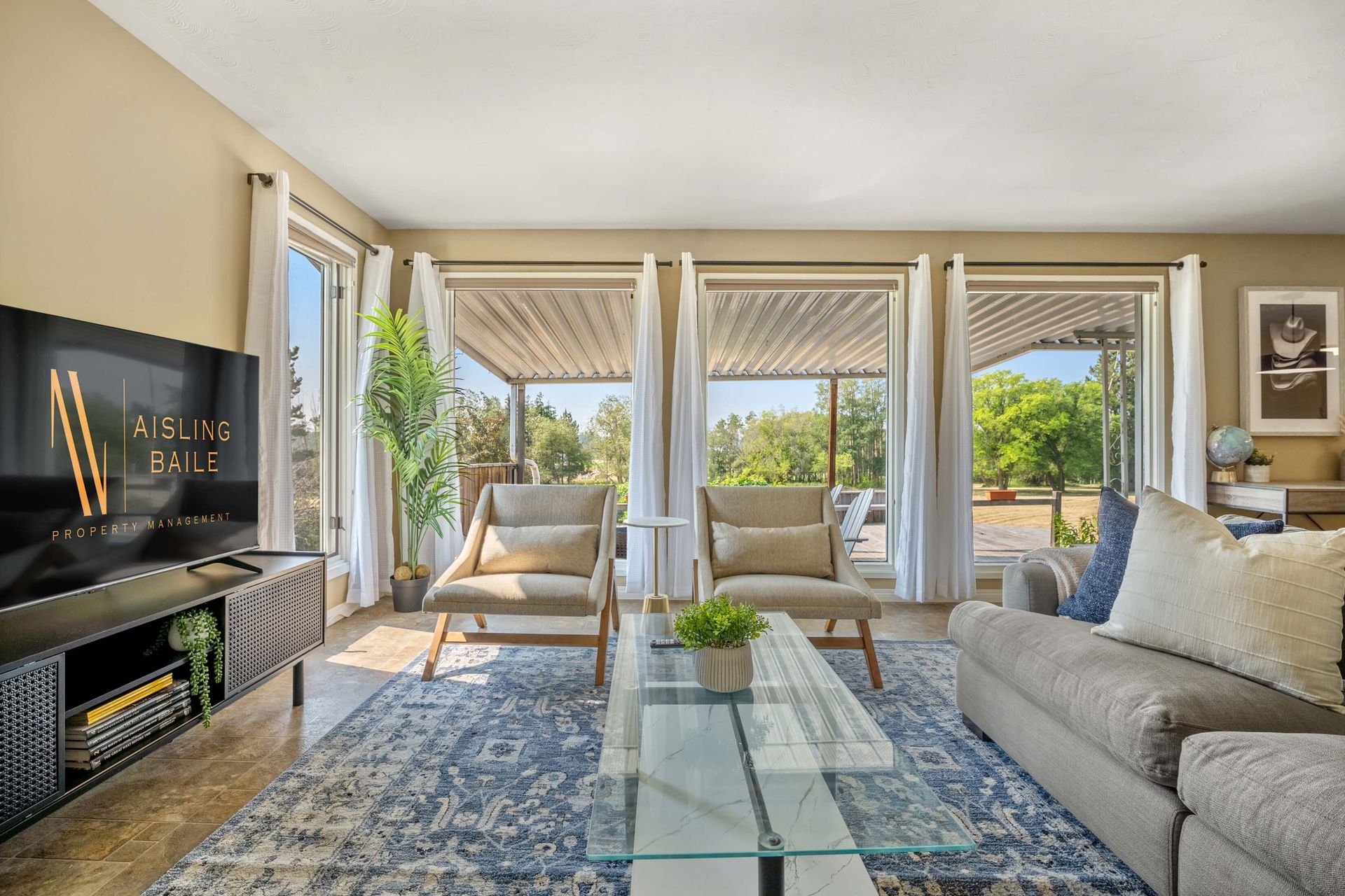 A living room with a couch , chairs and a flat screen tv
