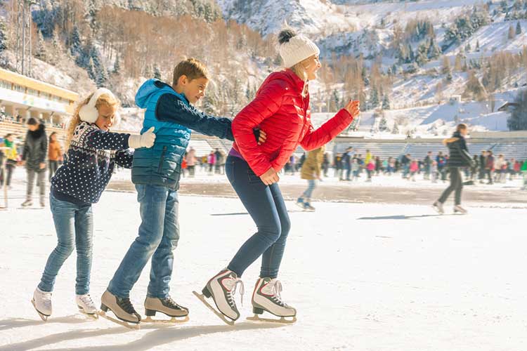 A group of people are ice skating on a rink.