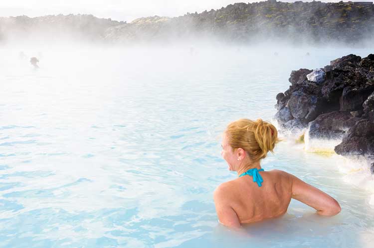 A woman is taking a bath in a hot spring.