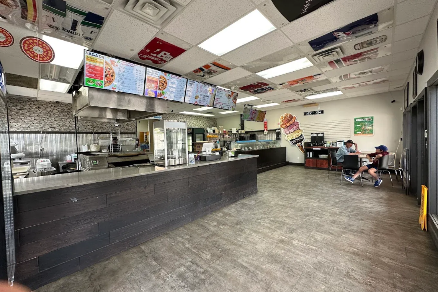 Empty fast-food restaurant interior with counter, menu boards, and seating area
