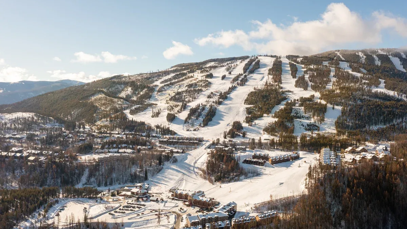 Snow-covered ski slopes on a mountain under a clear blue sky