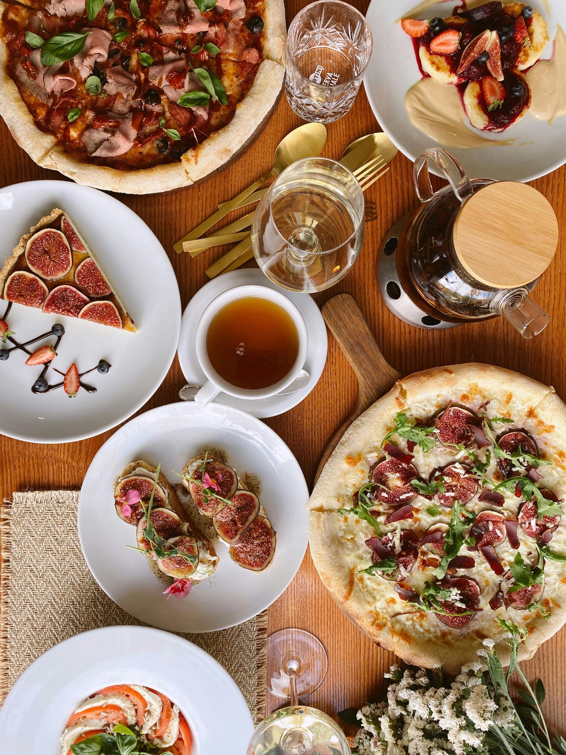 People sledding down a snowy hill surrounded by trees.