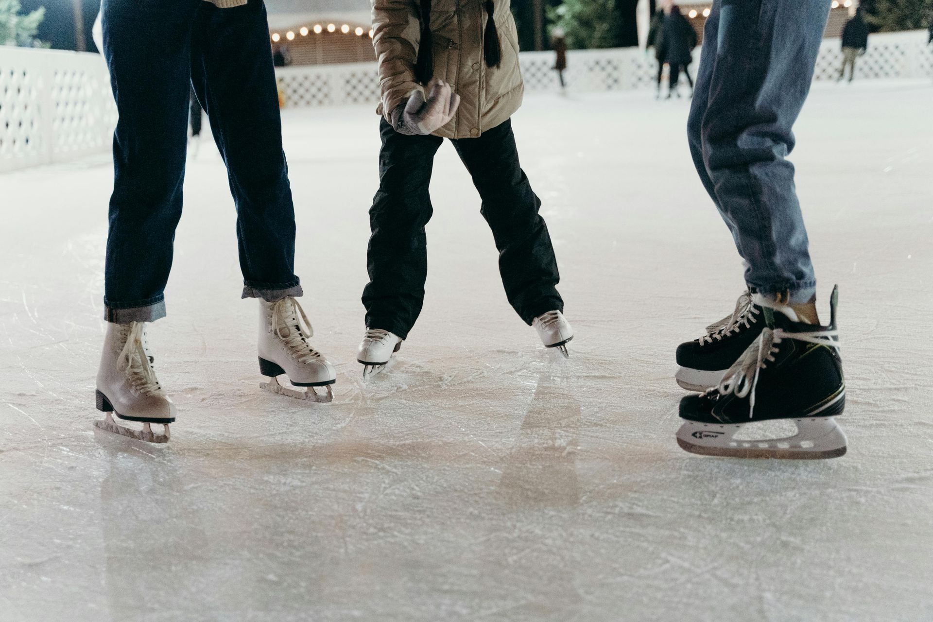 Two people ice skating on an outdoor rink.