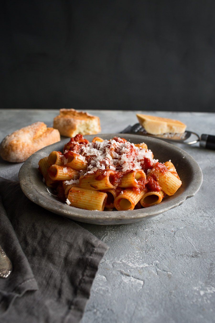 A plate of pasta with tomato sauce and cheese on a table.