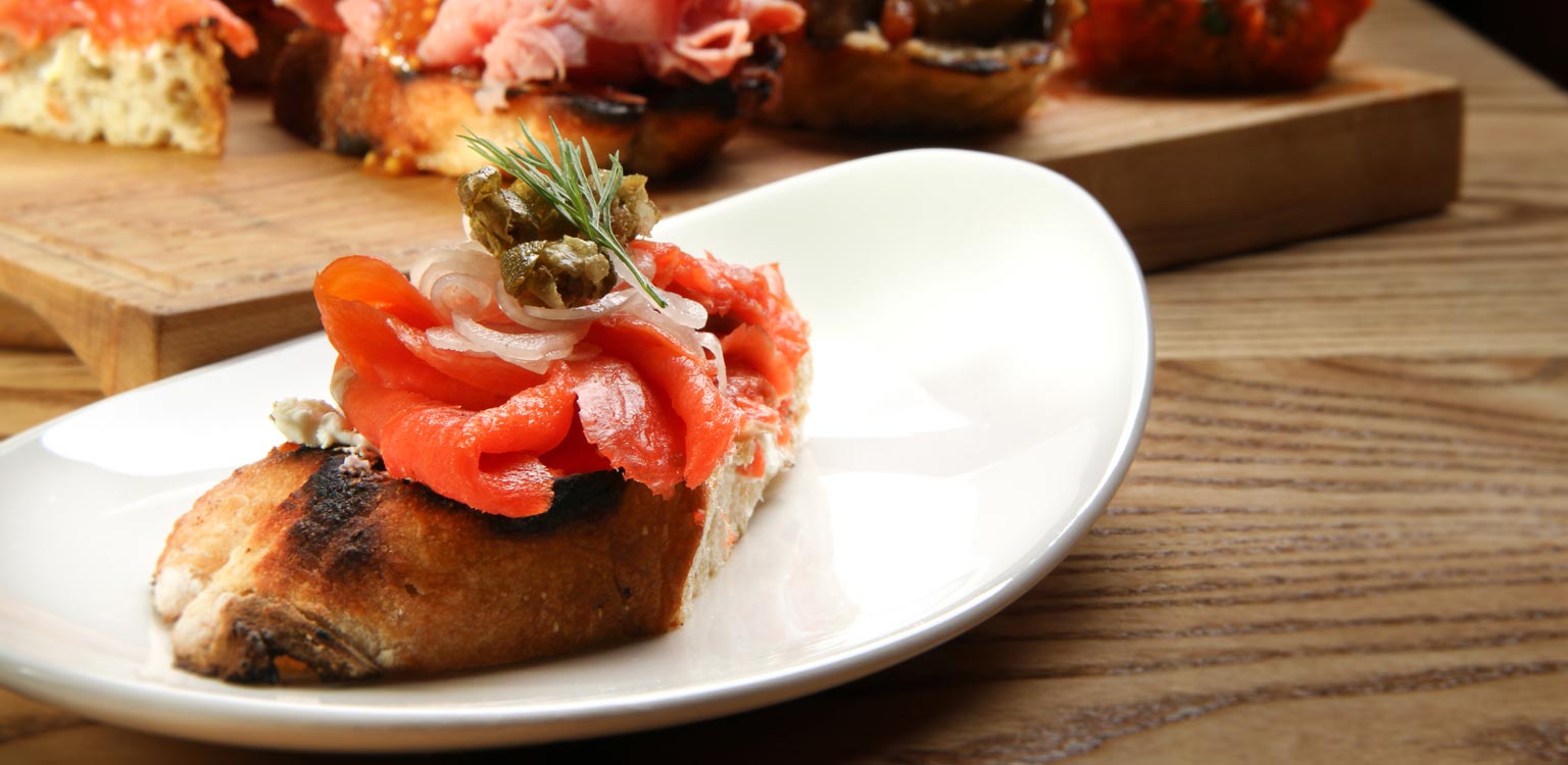 A close up of a plate of food on a wooden table.