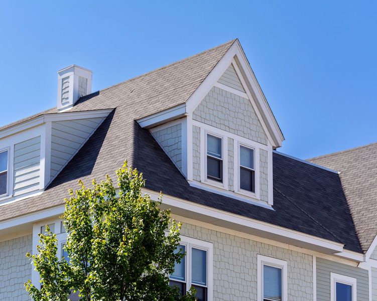 The roof of a house with a tree in front of it