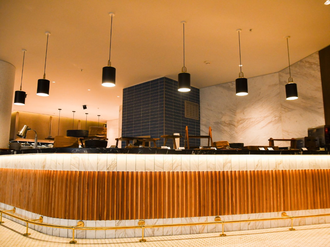 Un restaurante con un mostrador de madera y una encimera de mármol.