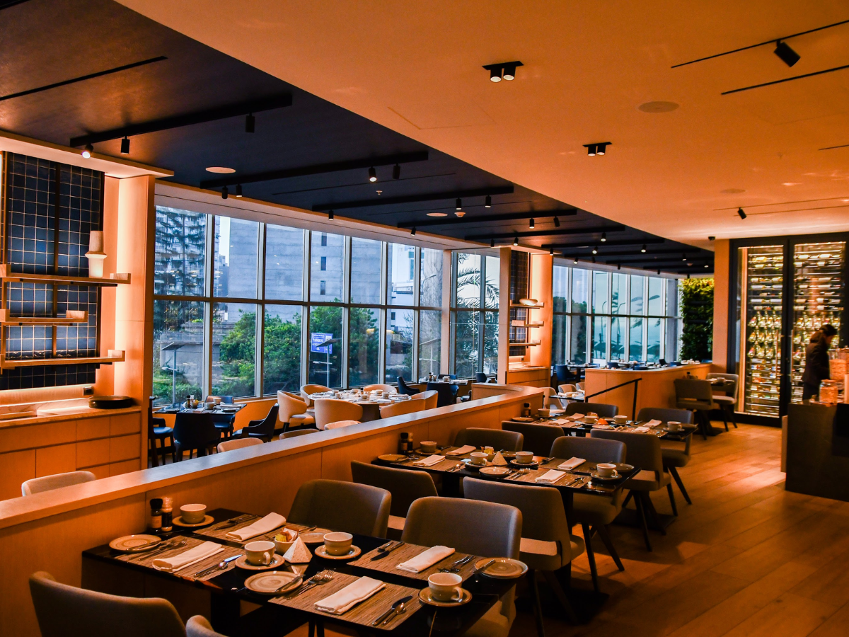 Un restaurante con mesas y sillas y muchas ventanas.