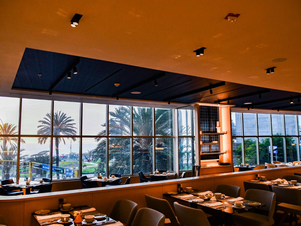 Un restaurante con mesas y sillas y muchas ventanas.