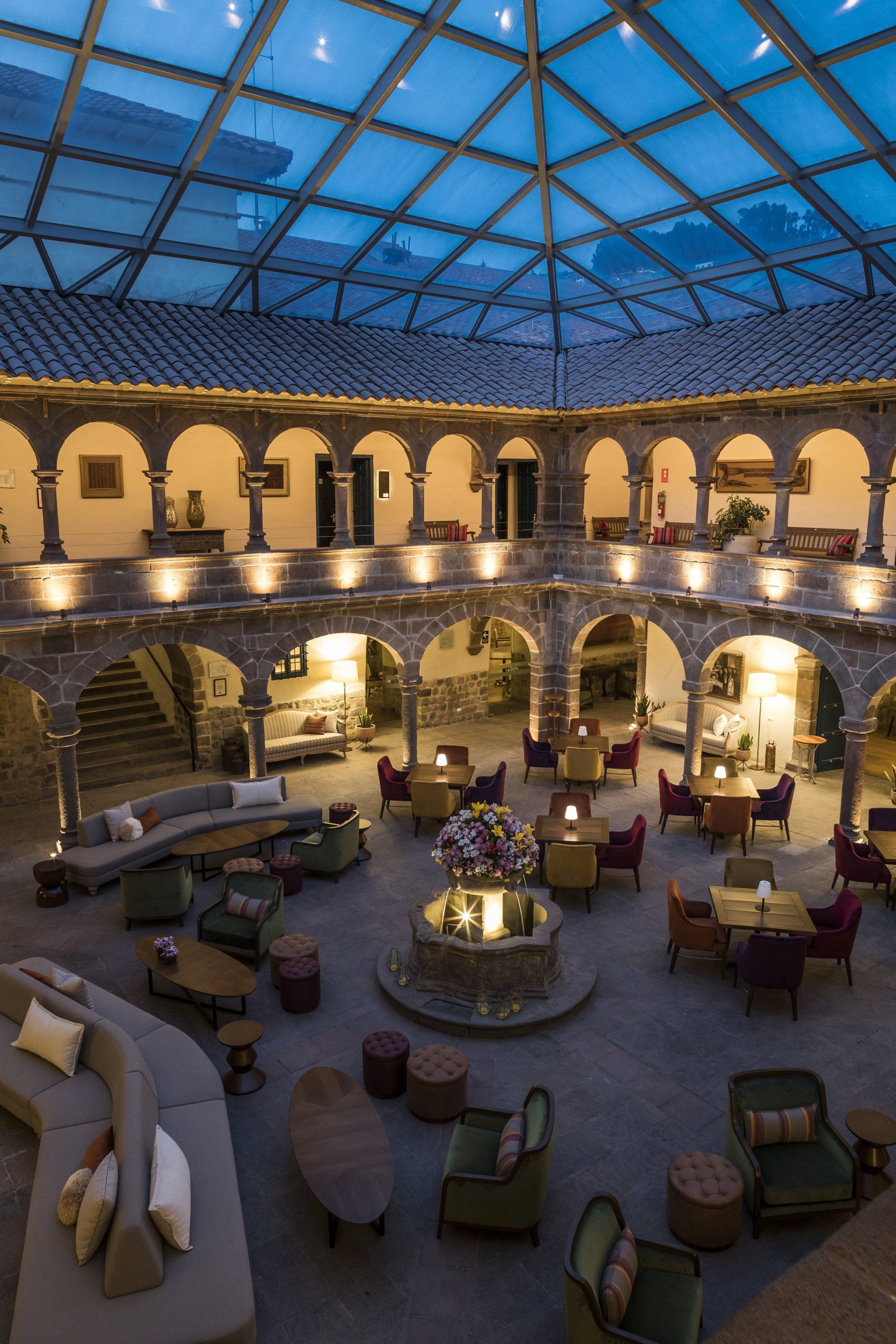 El interior de un edificio con techo de cristal y muchos muebles.