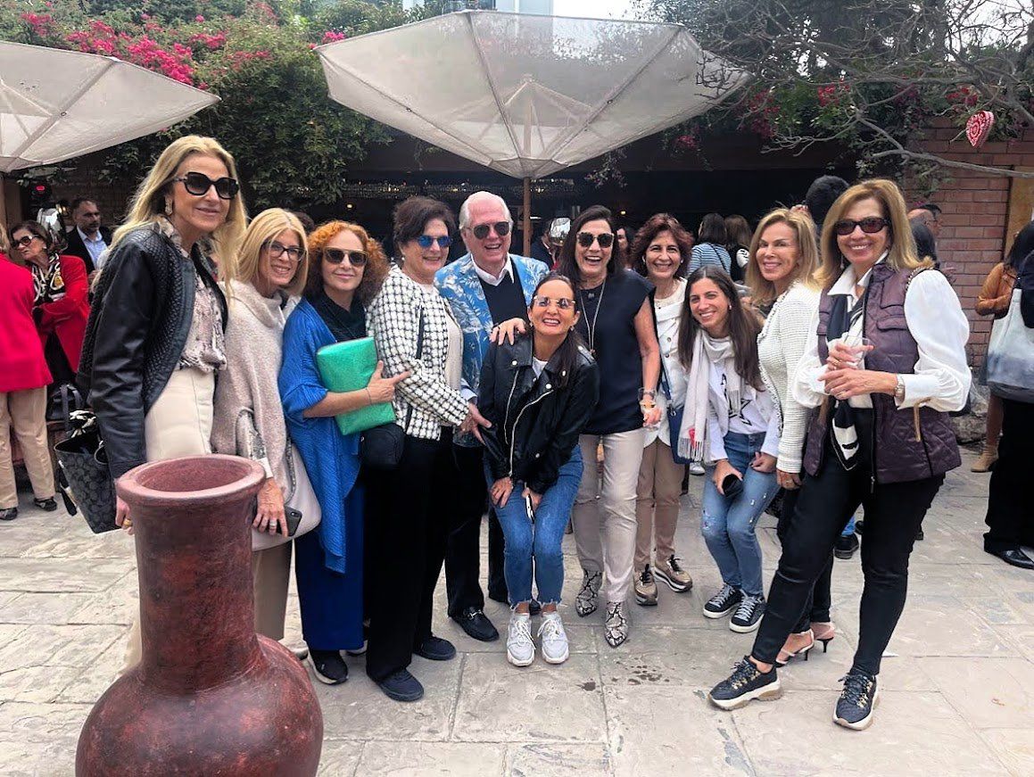 Un grupo de personas posan para una fotografía delante de un jarrón.