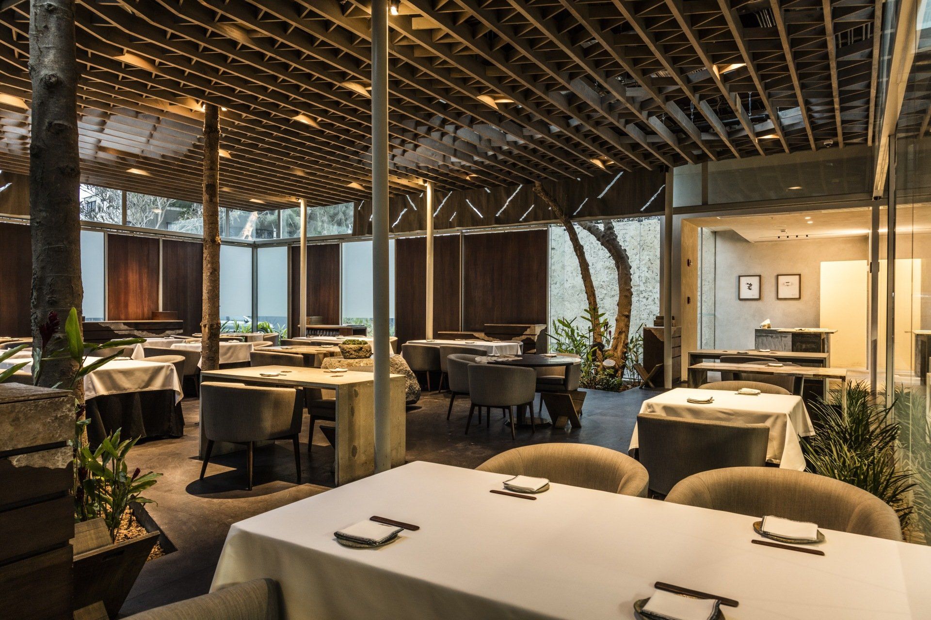 Un gran comedor con mesas y sillas y techo de madera.